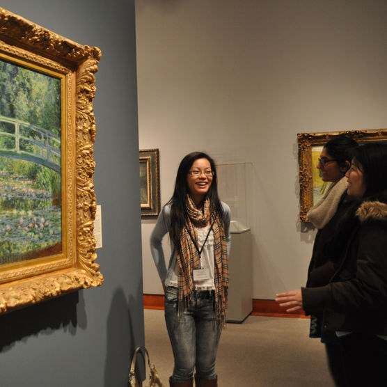 Student volunteers tours paintings in the museum